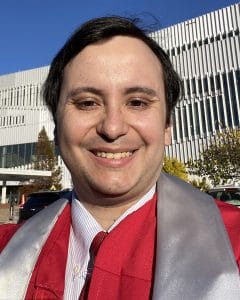 Headshot of Francisco Ortiz wearing a red graduation robe.