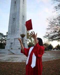 Mengyang Wei throws her mortar board in the air near the Memorial Belltower.