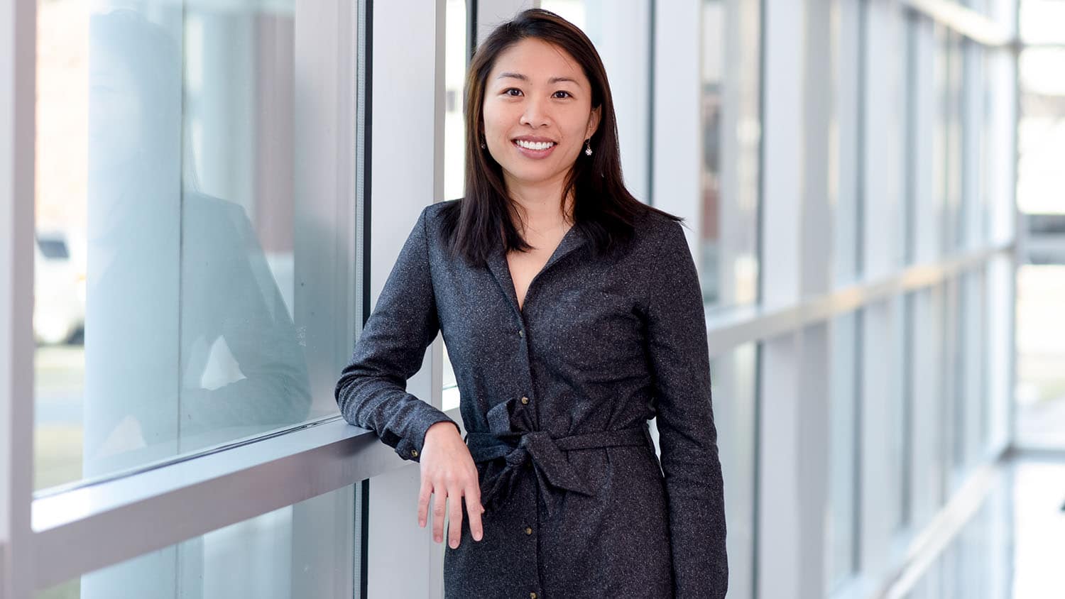 Lilian Hsiao, an Asian American woman, stands in front of a window