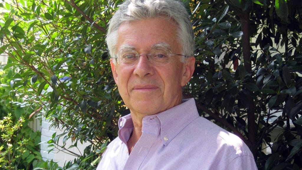 Robin Moore in front of leafy green trees.