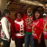 A group of alums pose at an ugly Christmas sweater event.