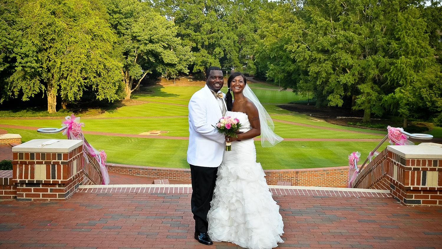 McKinlay and LaTeisha Jeannis stand for a portrait overlooking the Court of North Carolina wearing their wedding attire.