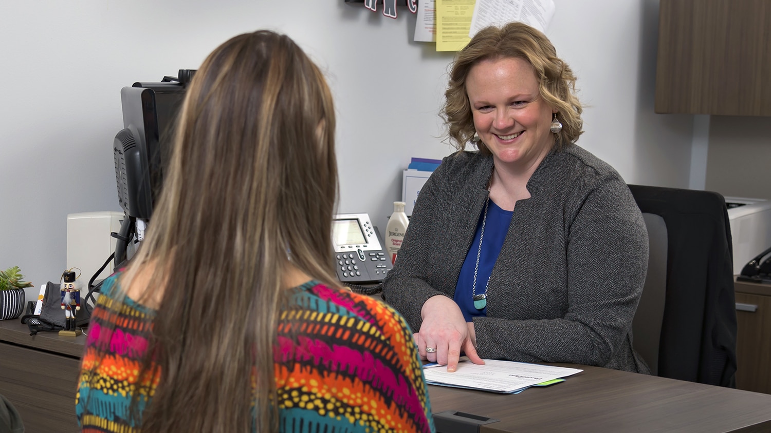 Amanda Buchanan assisting student in her financial aid office.