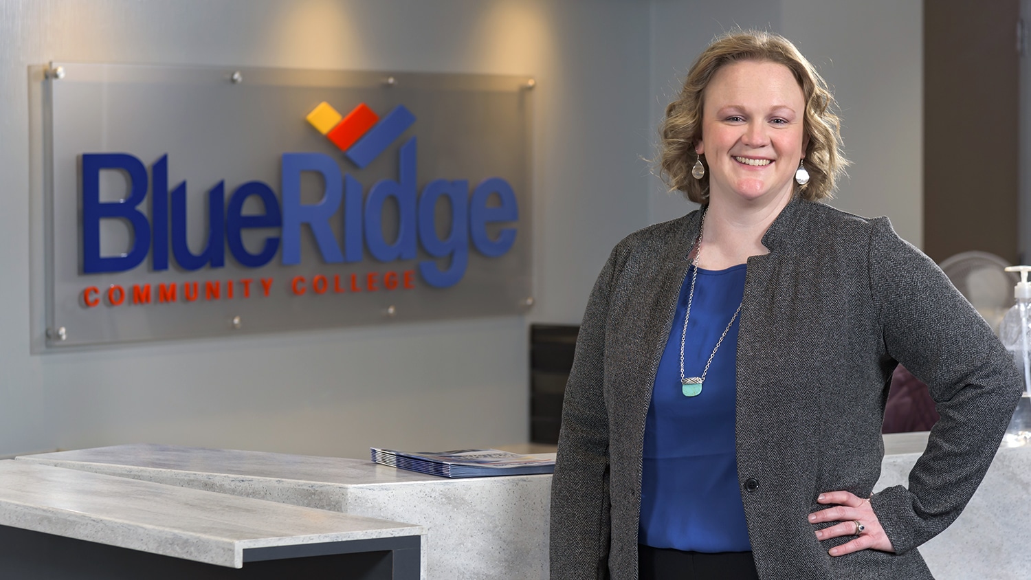 Amanda Buchanan posing in front of sign in financial aid office at Blue Ridge Community College.