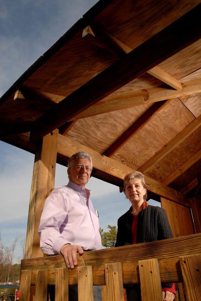 Robin Moore and Nilda Cosco looking down from a treehouse.