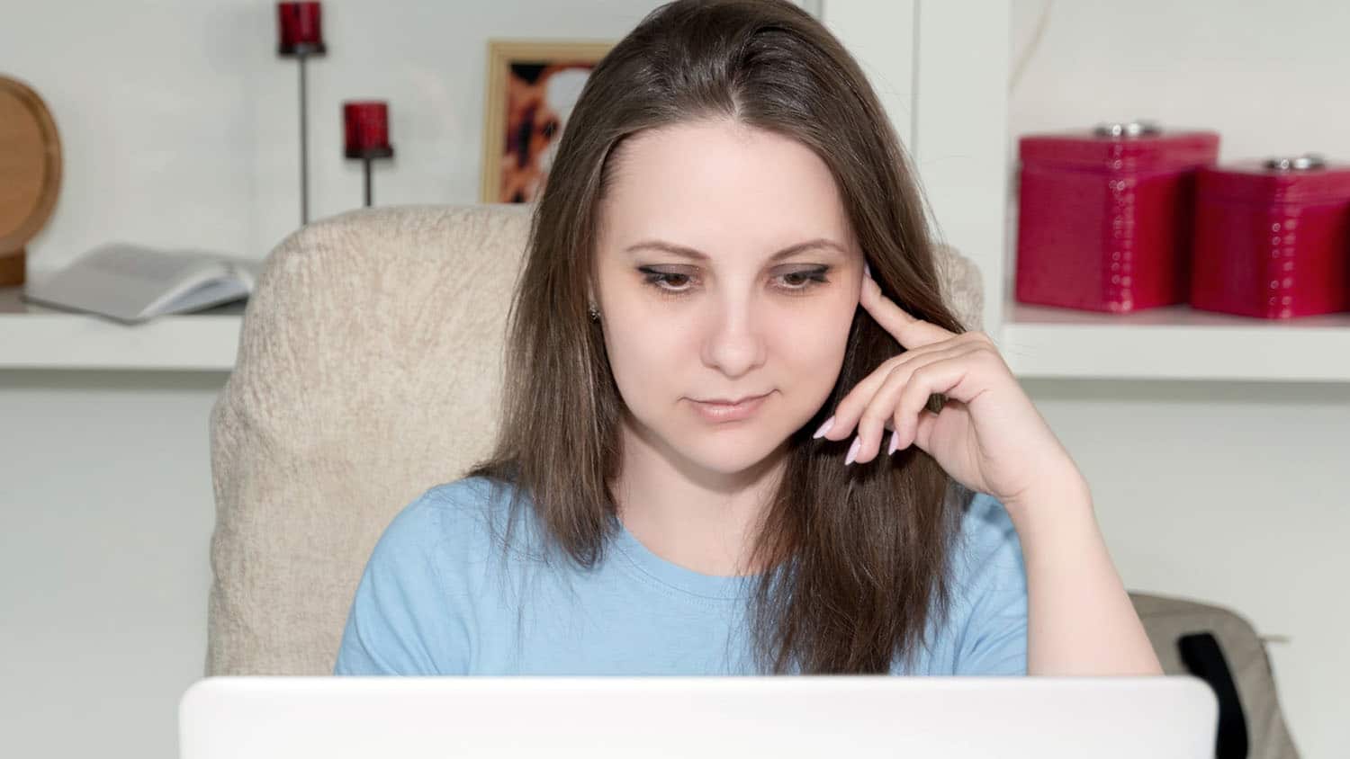 confused woman looks at a laptop screen