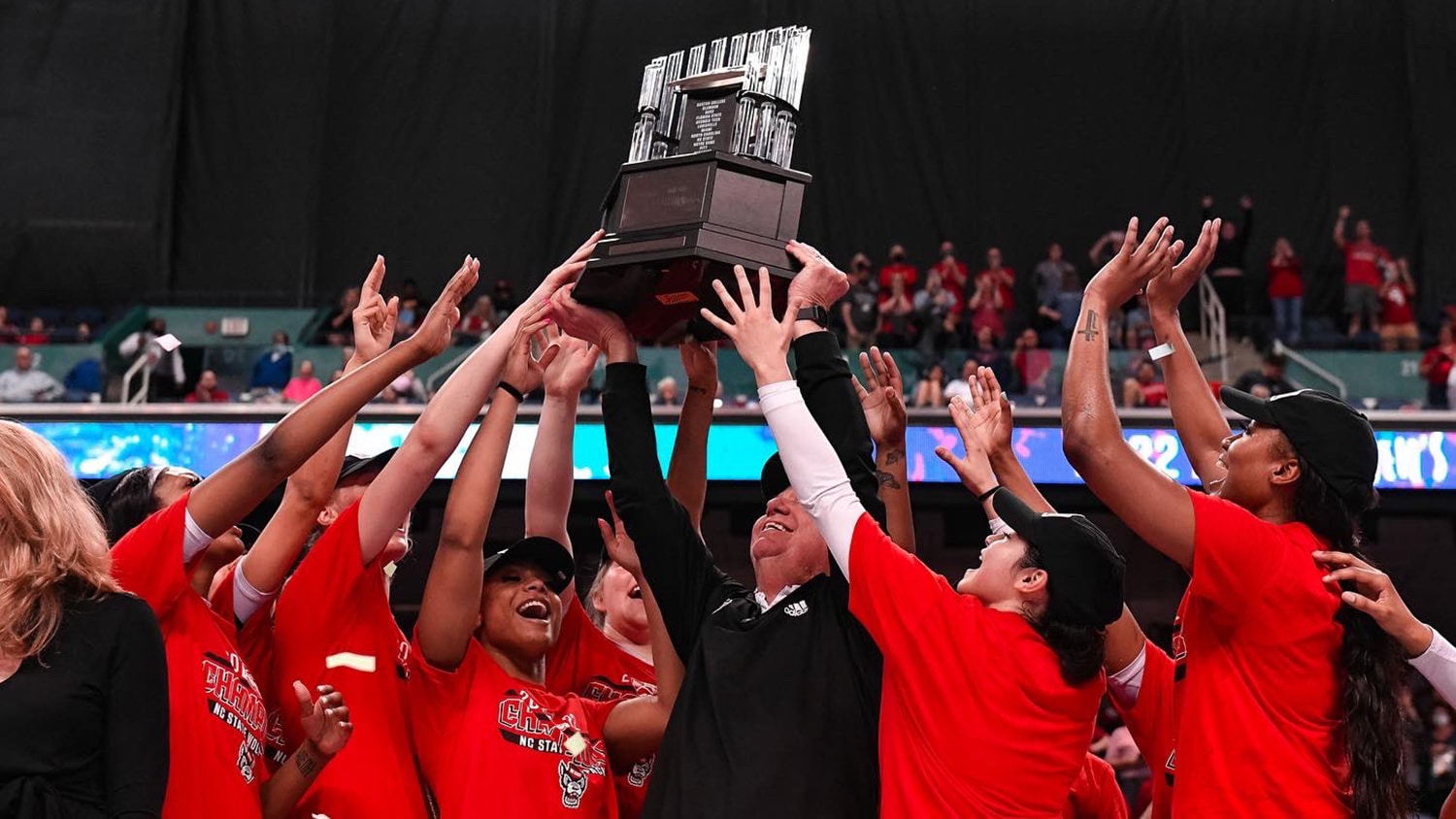 Moore and team holding ACC trophy over their heads.