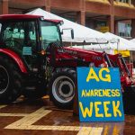 A tractor sits in the Brickyard near a sign reading "Ag Awareness Week."