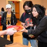 Students grab pizza at a Day of Giving student event.