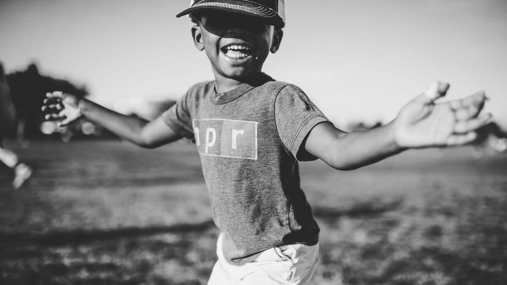 Black and white photo of child playing outside.