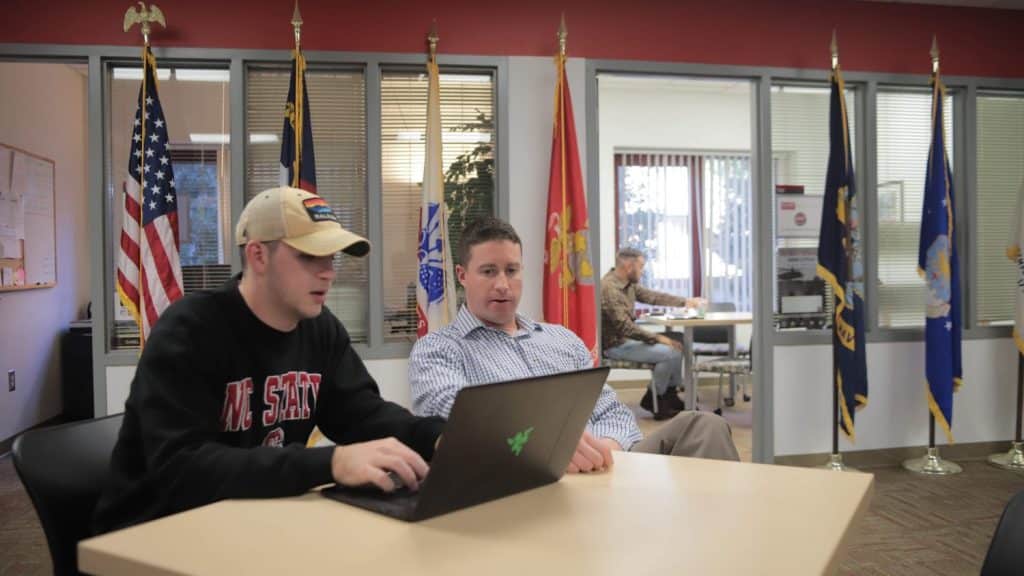 A student sits with the director of the Jeffrey Wright Military and Veteran Services in the center's office.