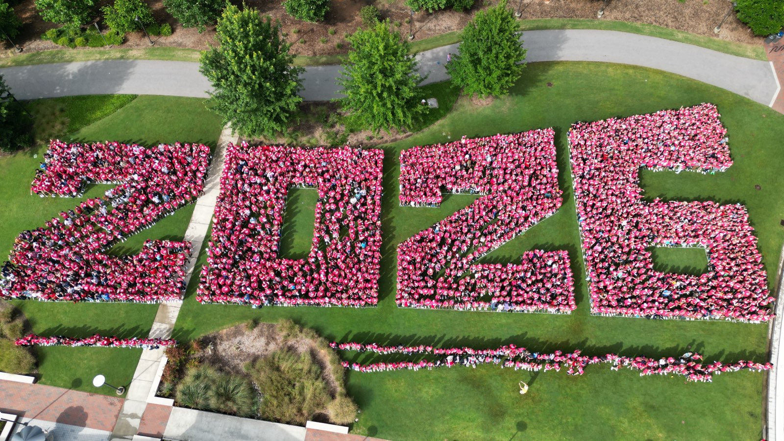 The Class of 2026 takes part in an annual Wolfpack Welcome Week tradition: posing for their class photo. An aerial shot shows students forming the shape of their graduating year, 2026.