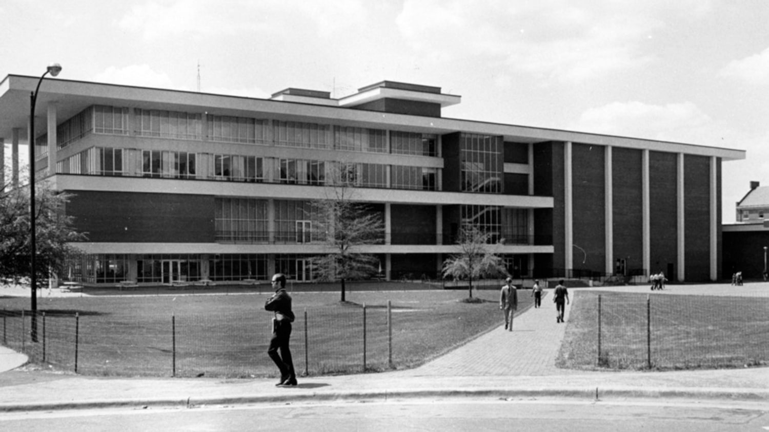 Black and white exterior photo of the original University Student Center with people walking by.