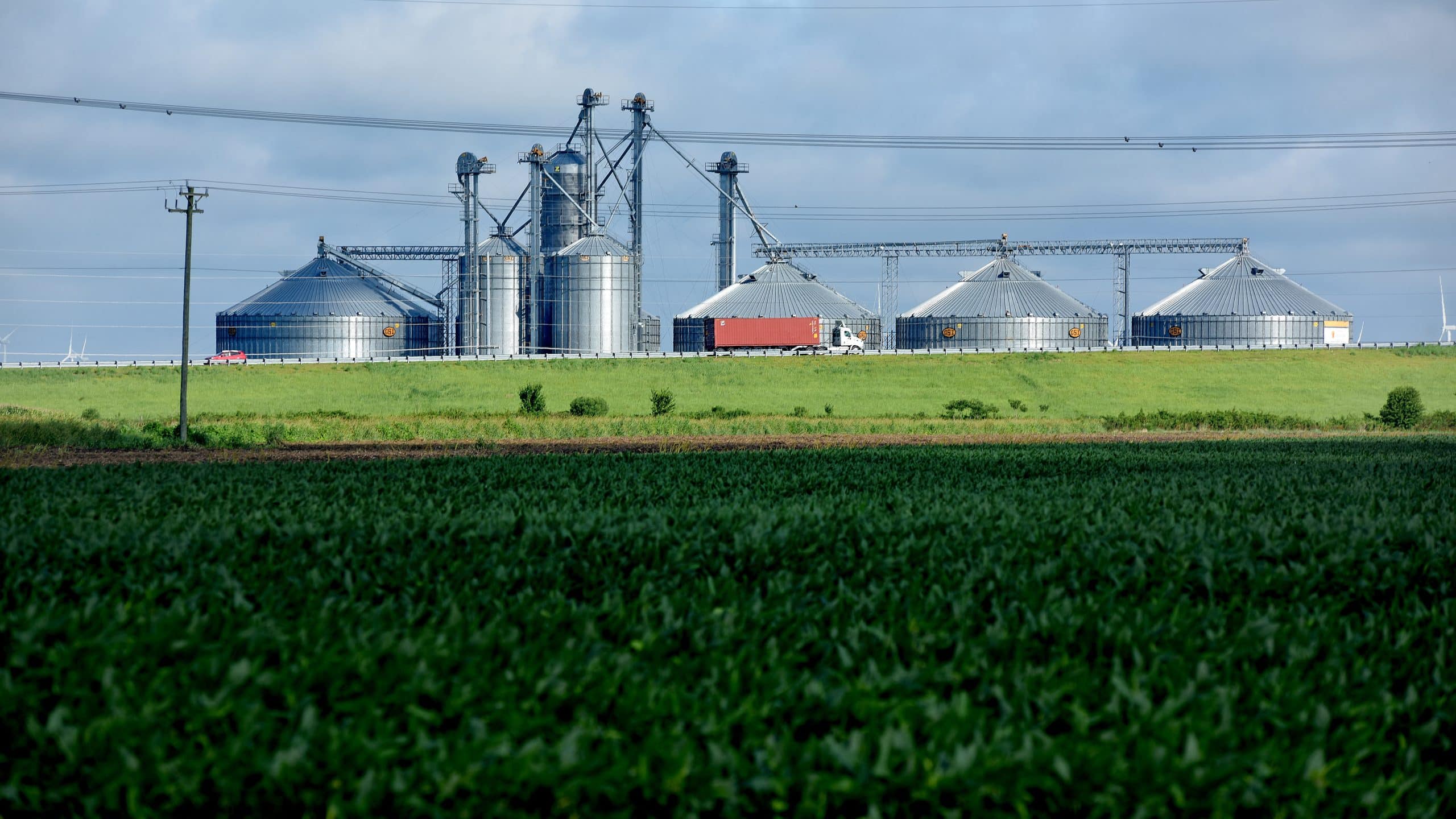 Truck roars past grain silos and wet fields in Pasquotank County.