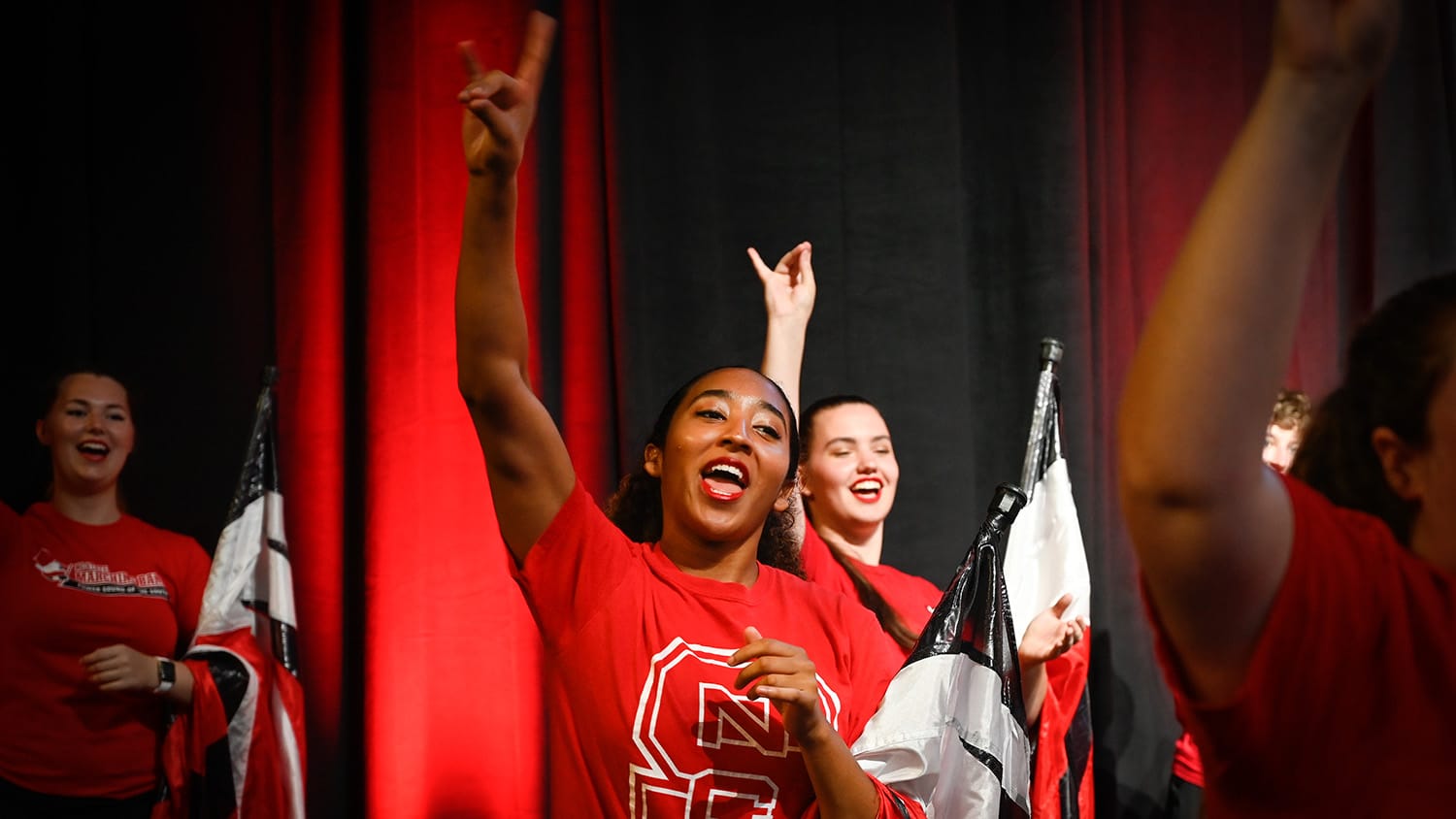 Student performers hype up the crowd (and throw up their wolf hands) at a Wolfpack Welcome Week event.
