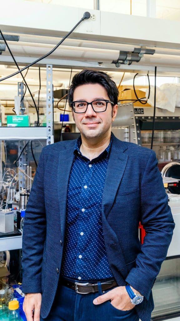 Milad Abolhasani stands for a portrait in his chemistry lab.