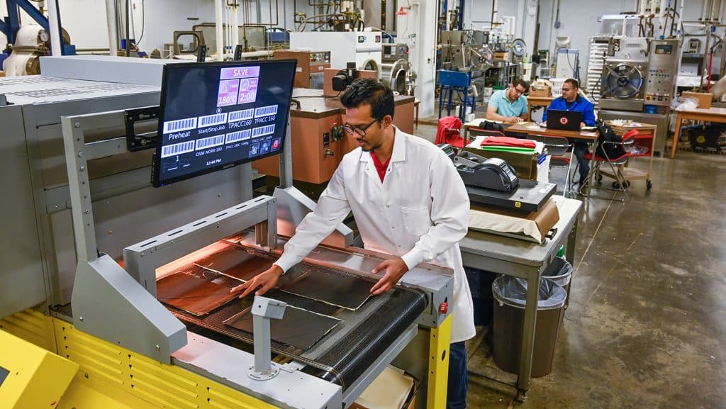 Student works with a giant scanner in a laboratory.