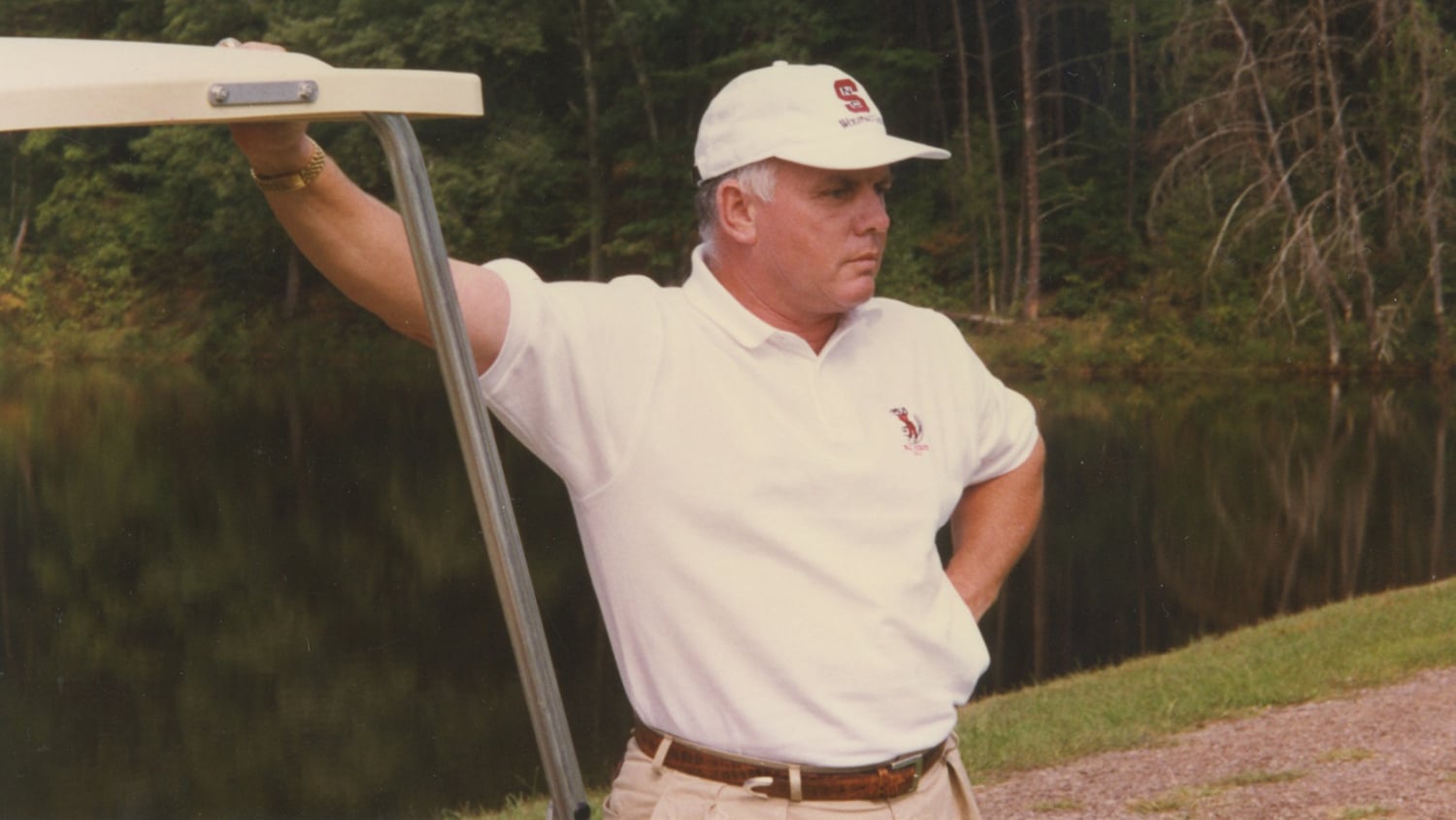 Richard Sykes standing next to a golf cart.