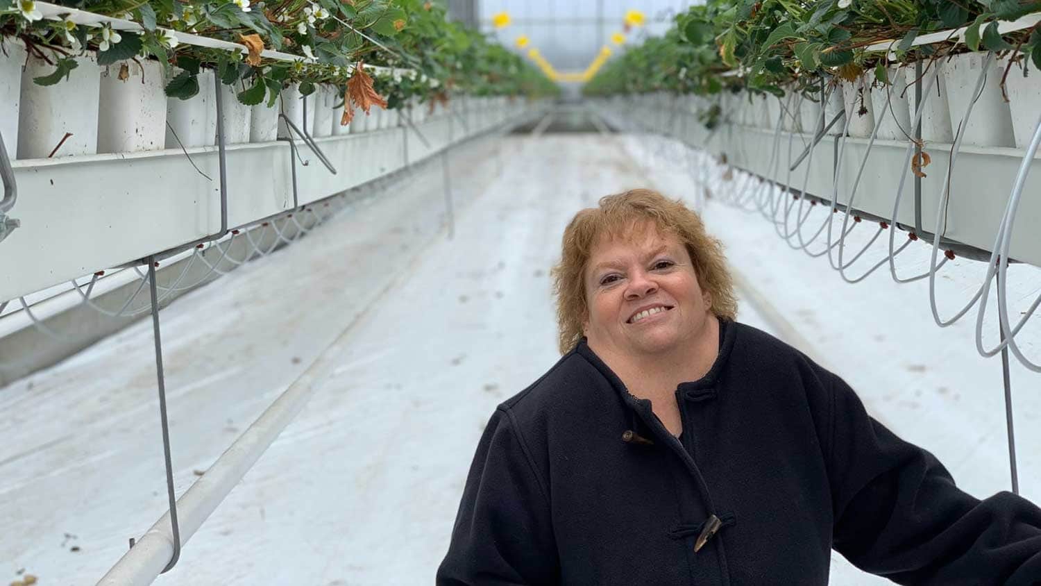 a woman standing in a greenhouse