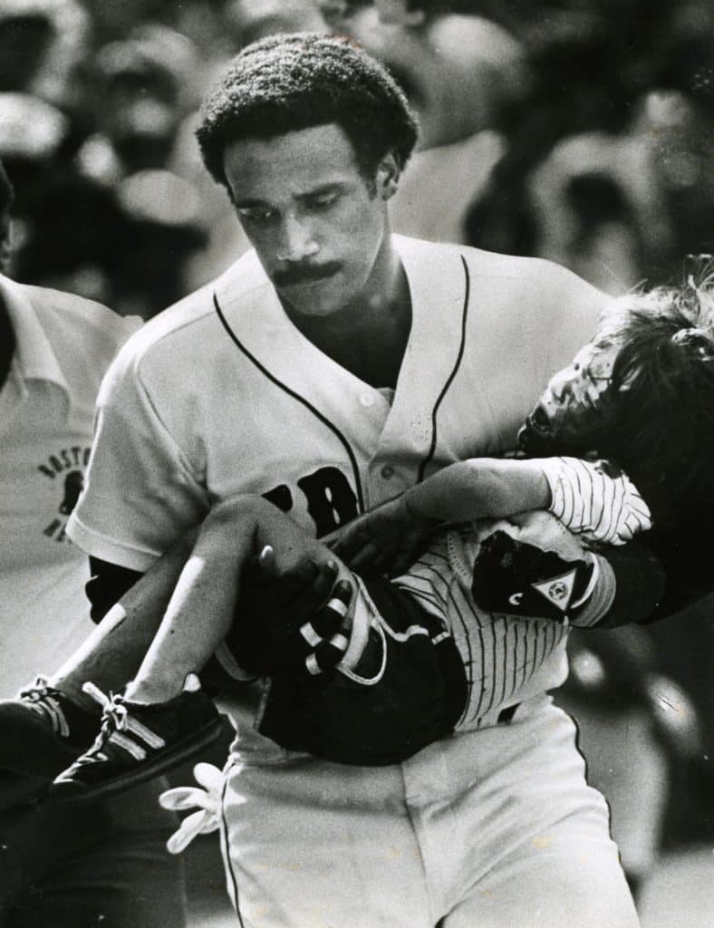 Outfielder Jim Rice carries injured Jonathan Keane to the Red Sox dugout during a 1982 game. 