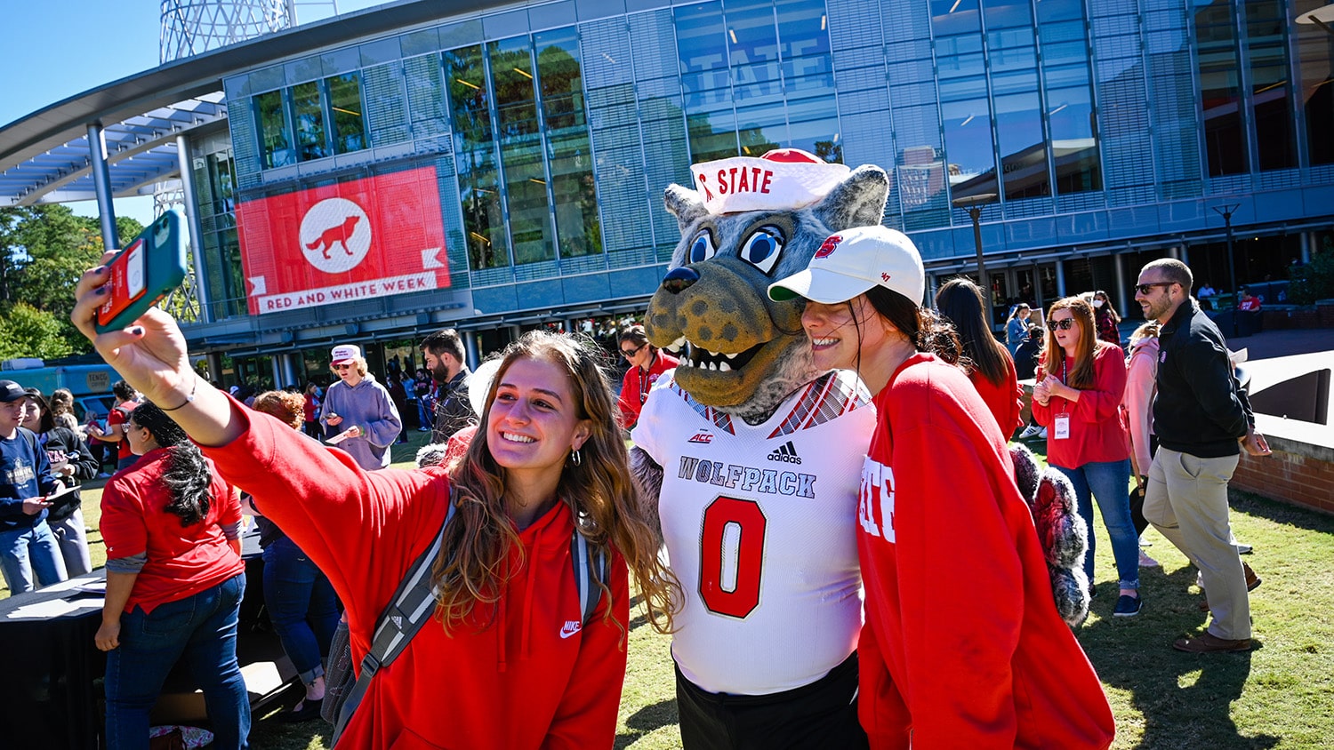 Students take a selfie with Mr. Wuf outside Talley Student Union.