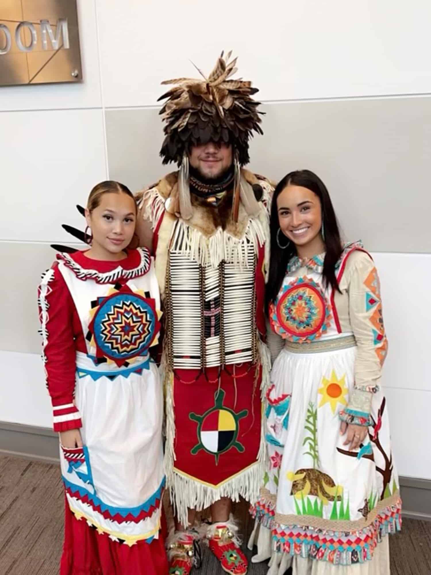 Students pose in traditional Native ceremonial dress.