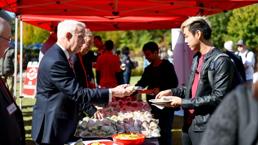 A student receives free food from a volunteer during Wear Red Get Fed.