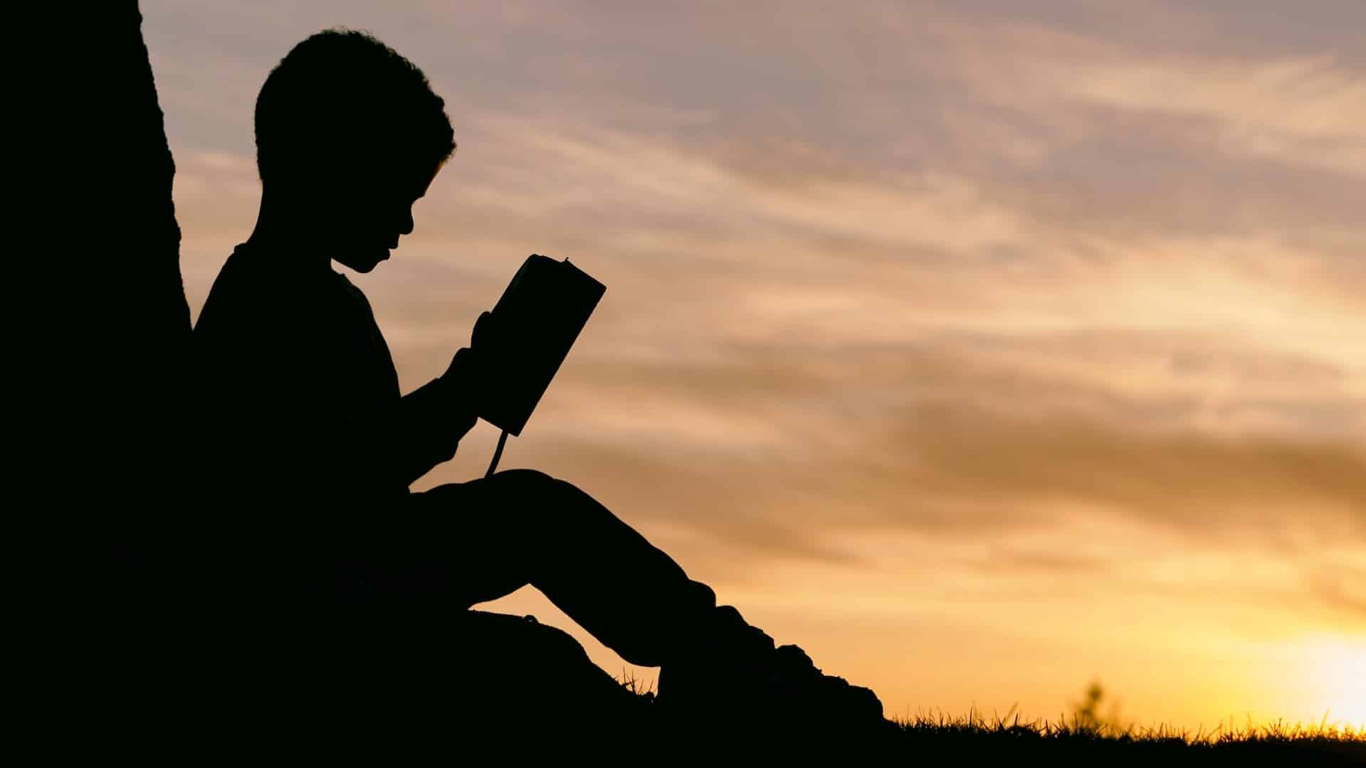 Silhouette of child reading