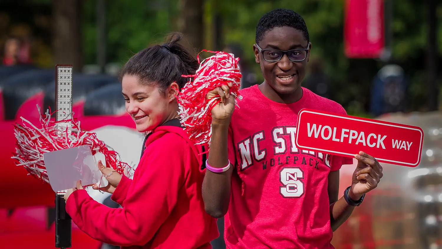 Two students pose in a photo booth during a student kickoff event for Red and White Week.
