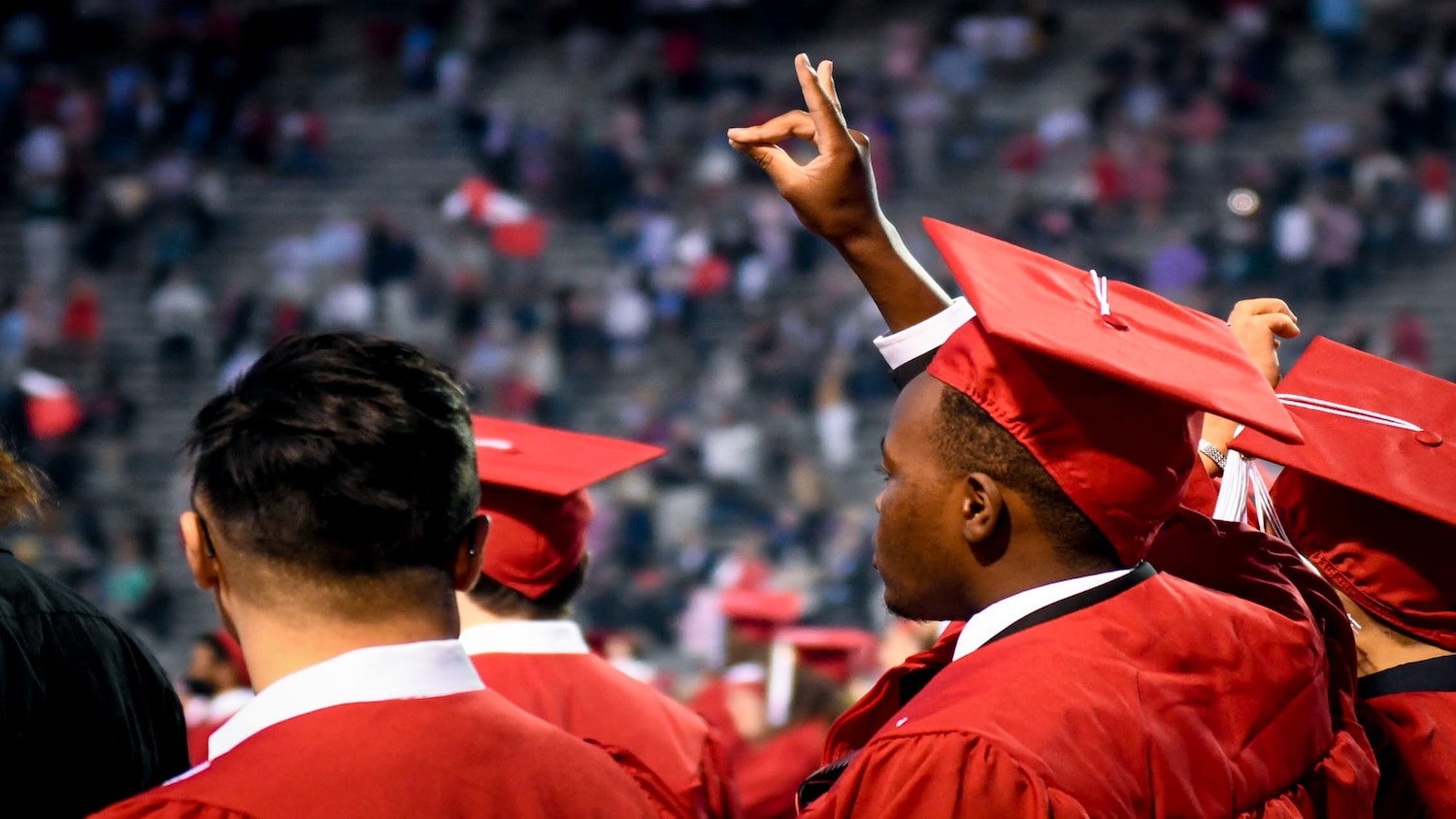 NC State graduate throws up the wolfie sign at commencement.