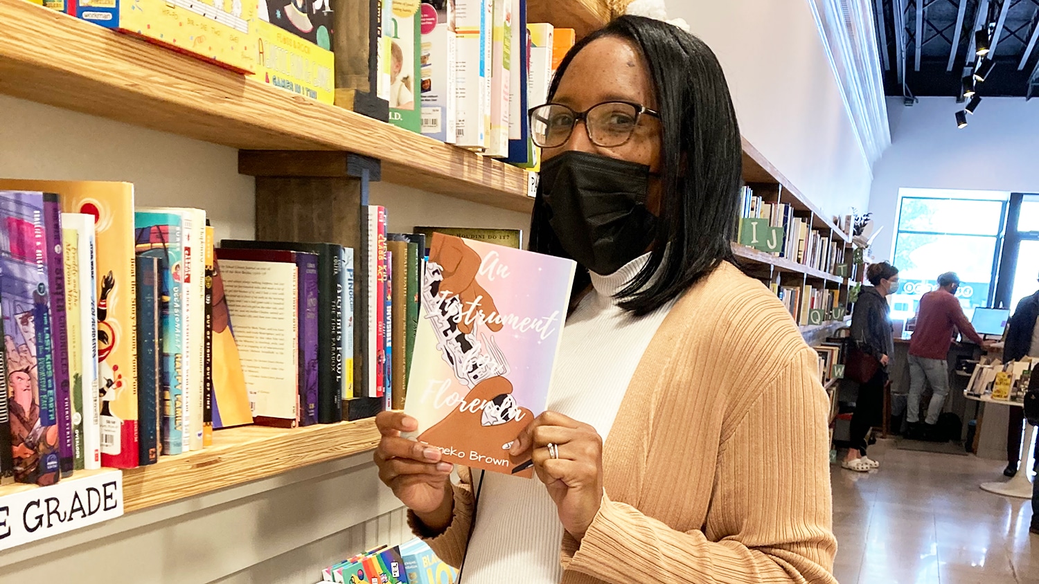 Tomeko Brown with a copy of her book at a bookstore