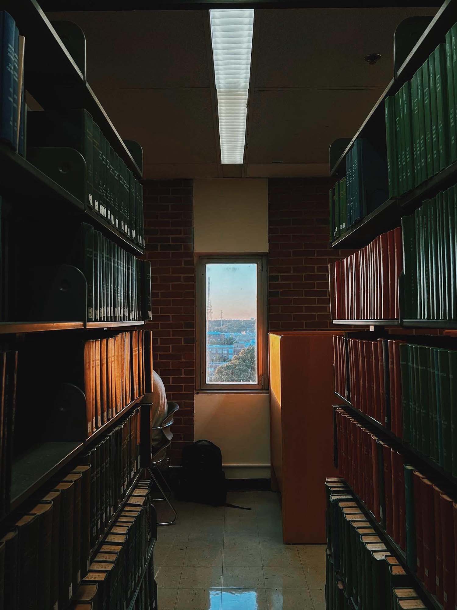 A small window illuminates the bookstacks in D.H. Hill Library with golden hour light.
