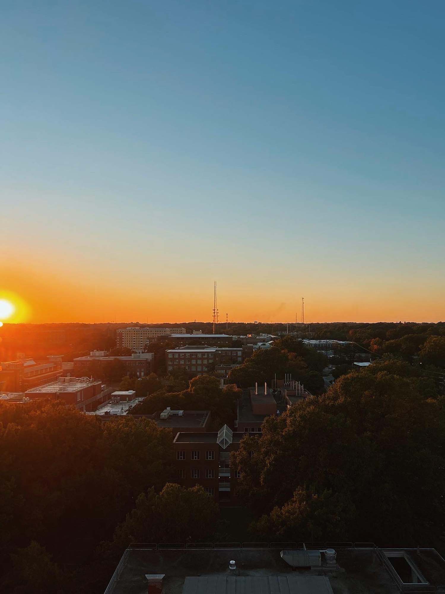 The fiery setting sun descends over NC State's campus.