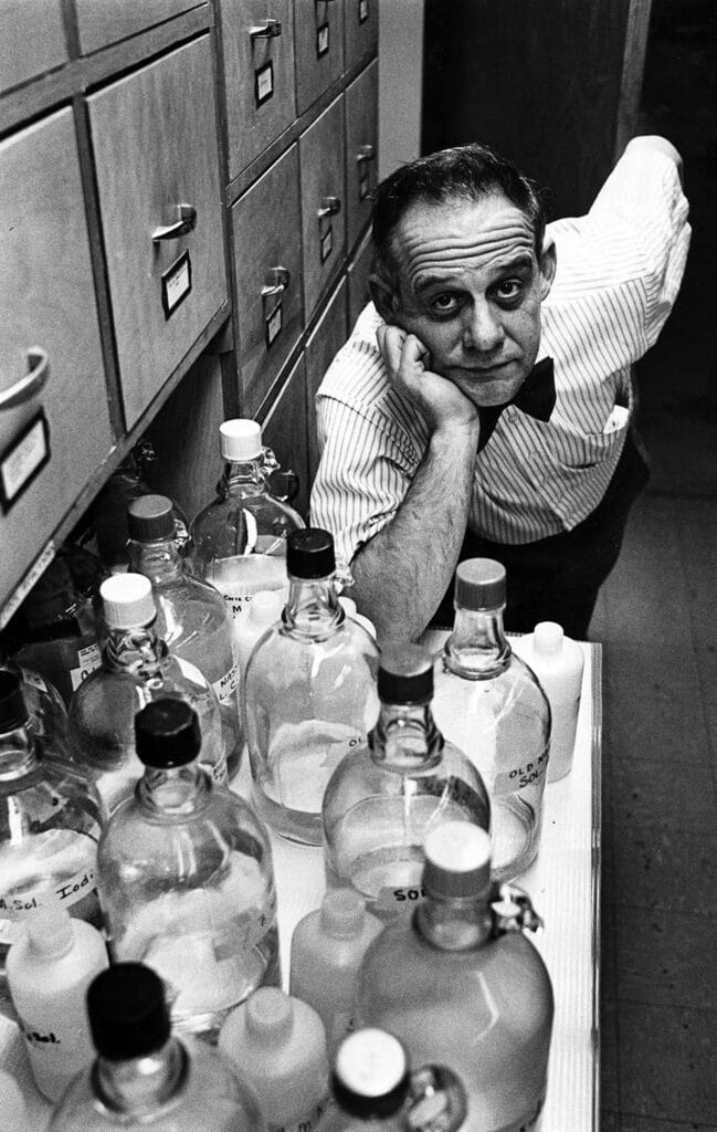 Hentz posing with a dozen bottles filled with chemicals in Dabney Hall.