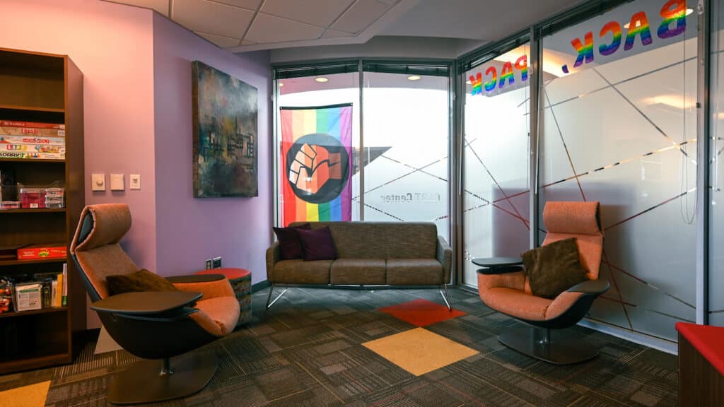 In the GLBT Center, a corner is set up with two large chairs and a gray couch.