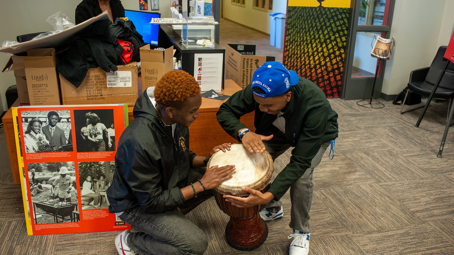 Students play a drum together in the African American Cultural Center.
