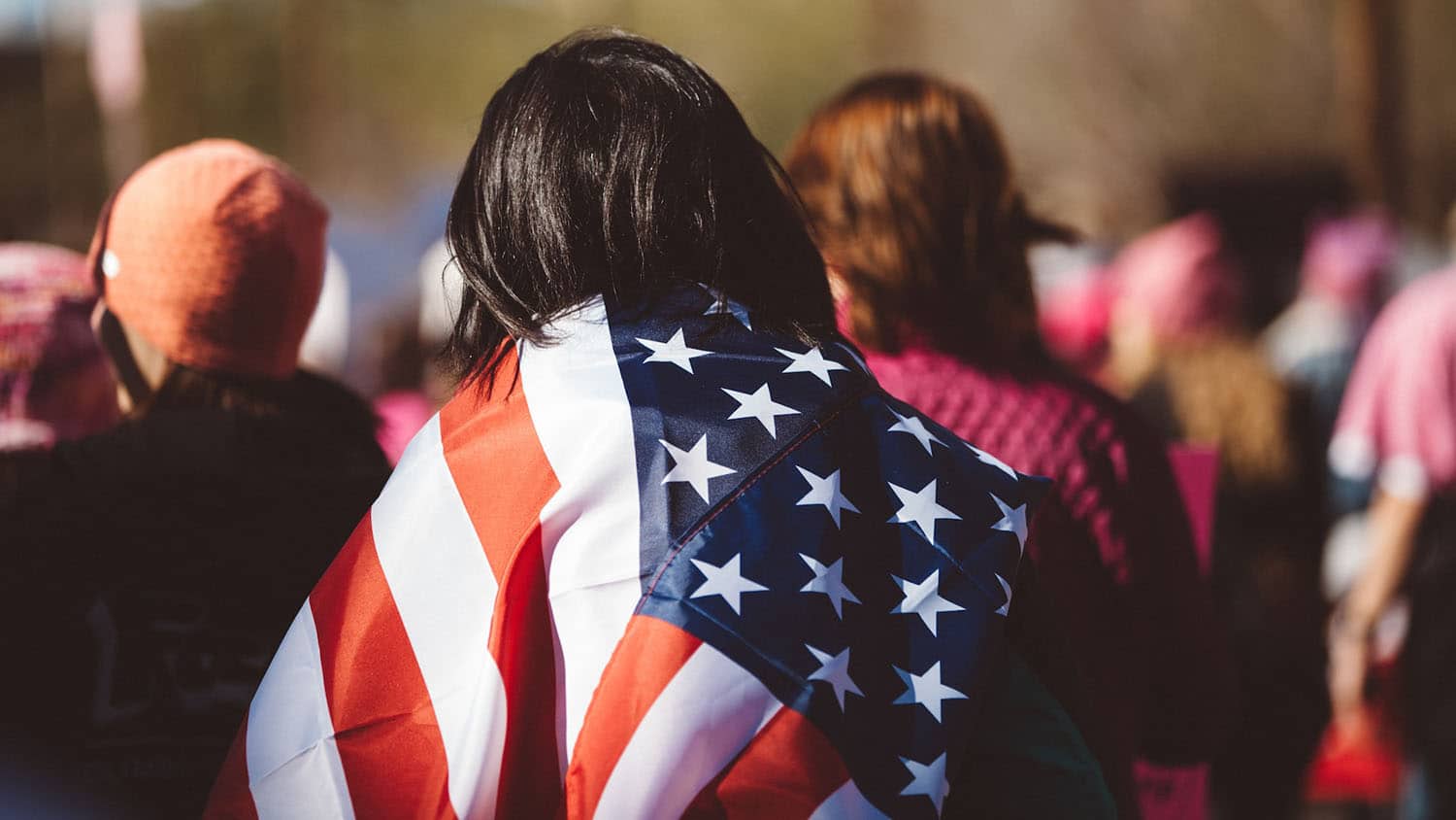 a person of indeterminate sex and race is wrapped in a U.S. flag
