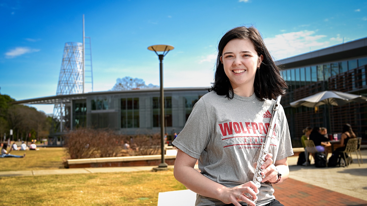 Katie Phillips holds her flute with Talley Student Union in the background.