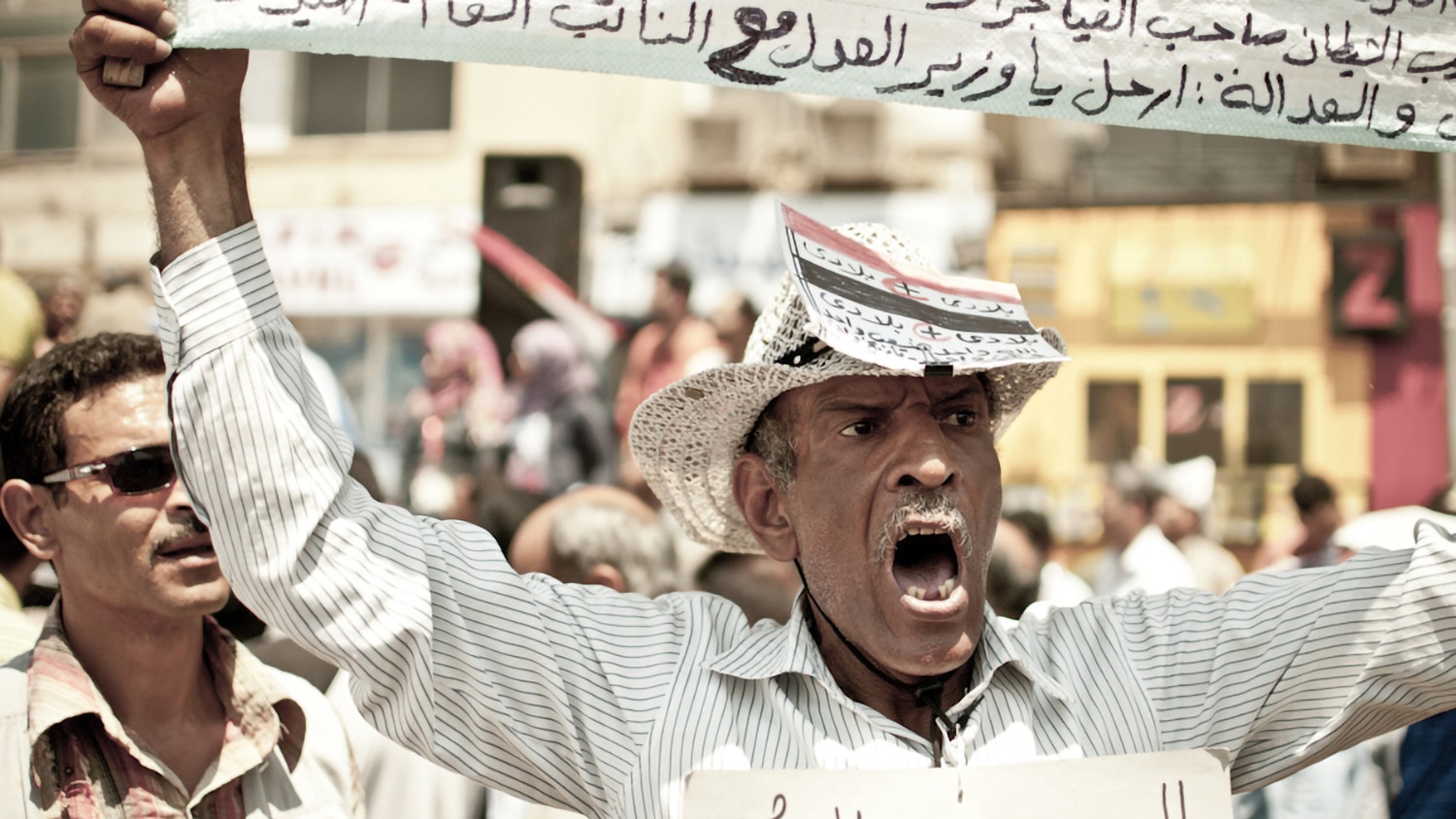 Man in the Middle East holding a protest banner.