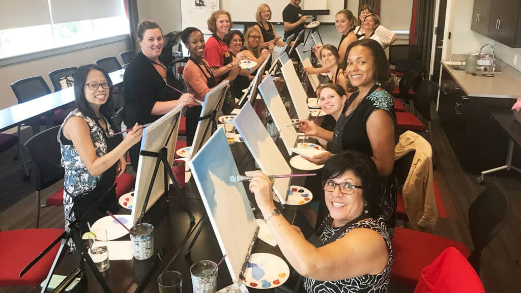 women painting canvases in an art class