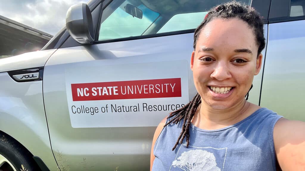 Murry Burgess in front of her car, which has a College of Natural resources sticker on it