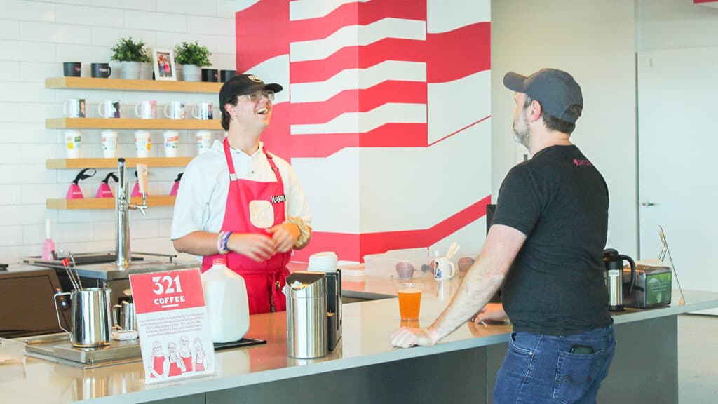 A 321 Coffee barista takes a drink order from a customer