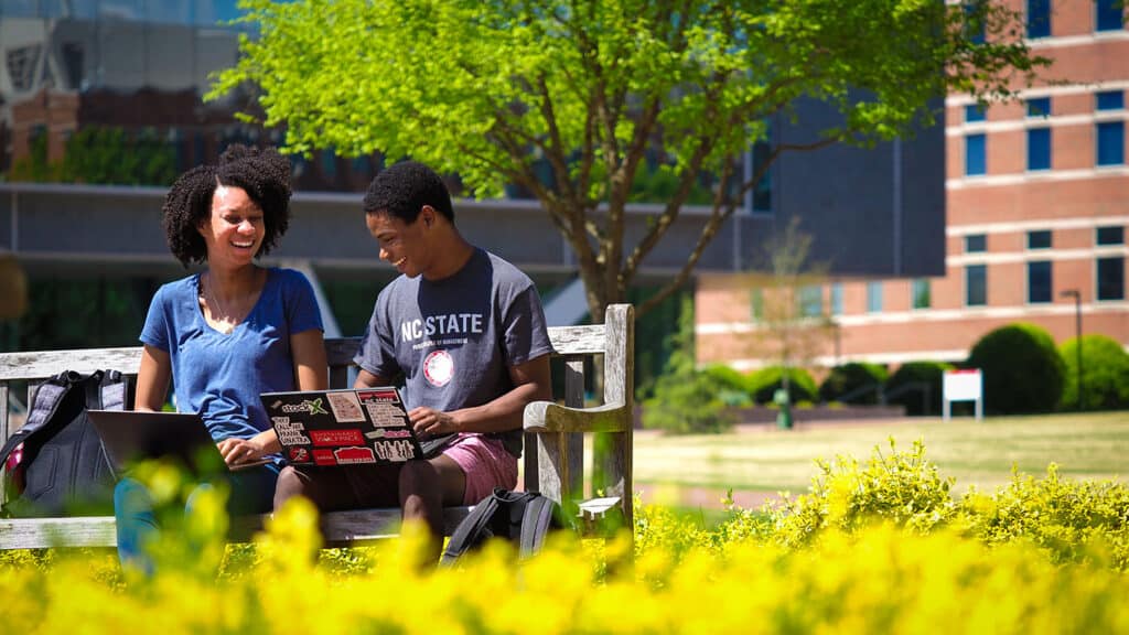 Students study and use laptops on the Engineering Oval on Centennial Campus.