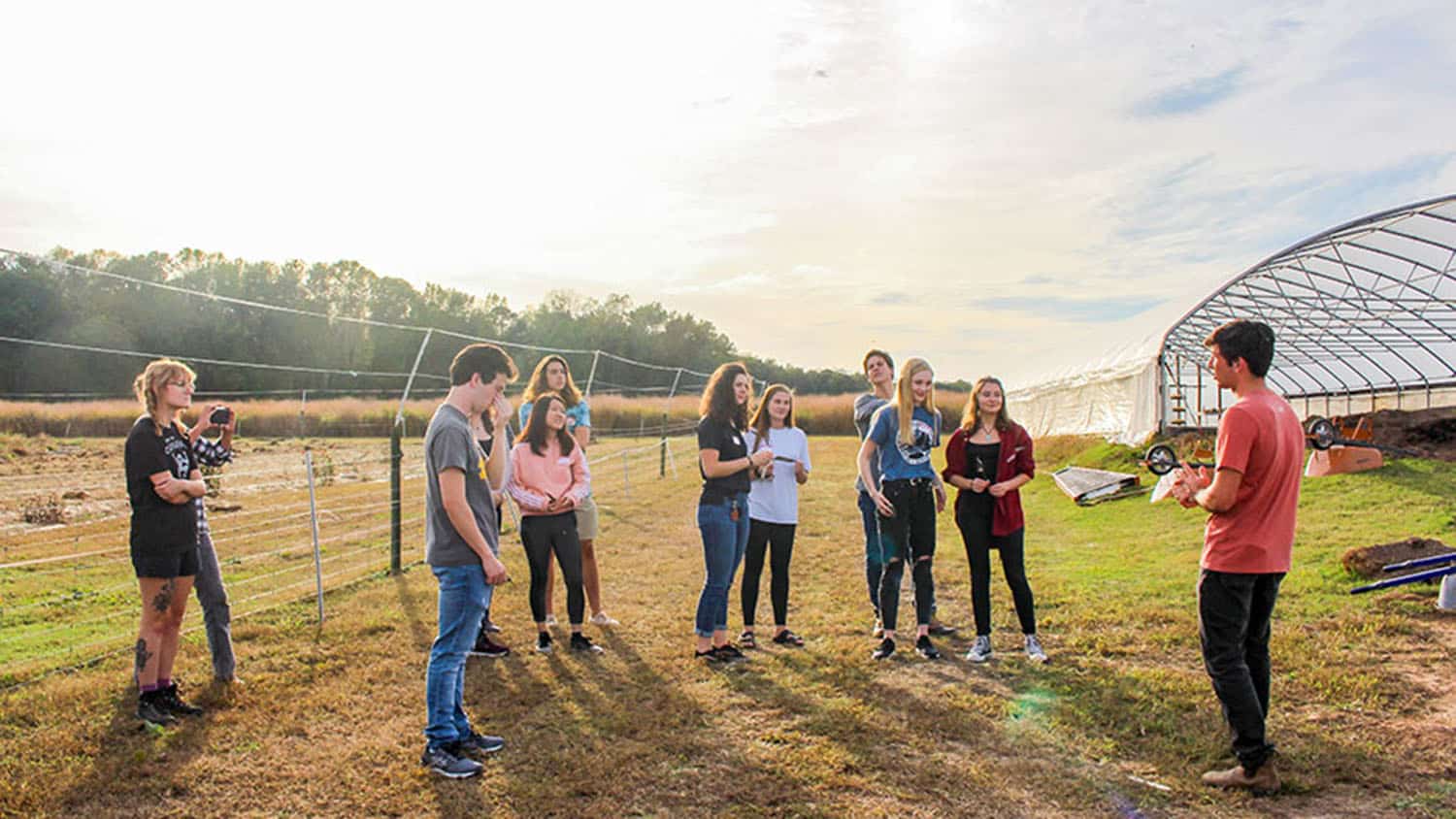 A group of Sustainability Stewards, student leaders that spearhead sustainable initiatives at NC State, discuss a project while outdoors.