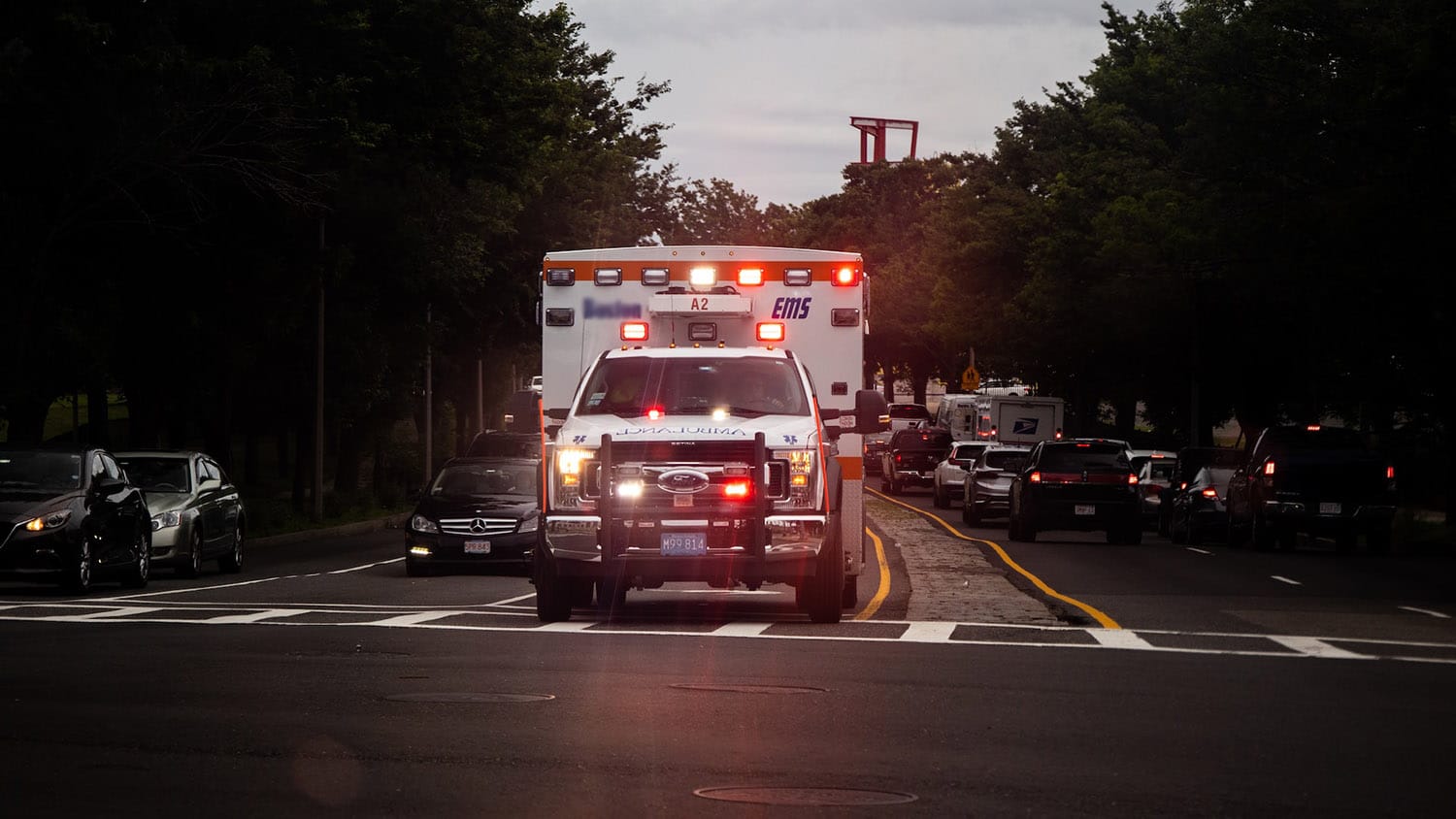 an ambulance passes through an intersection with lights flashing