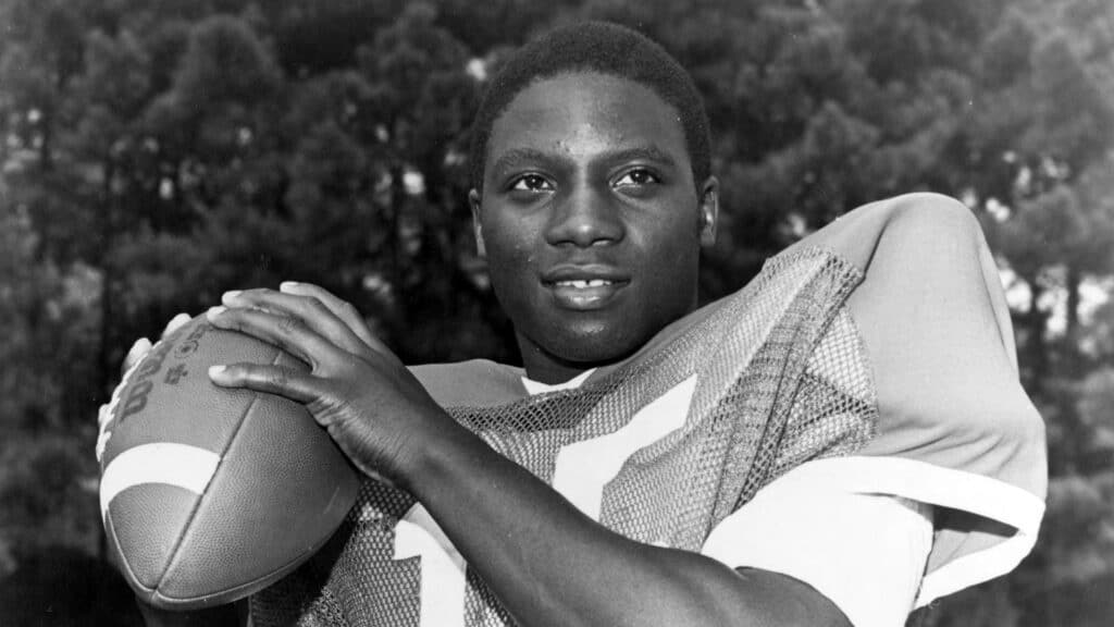 Tol Avery holding a football as a quarterback at NC State