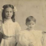 A toddler-aged Mary Yarbrough poses in a sepia-toned photo alongside her immediate family — her mother, father, and older sister.
