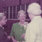 A color photo shows Mary Yarbrough candidly smiling while in discussion with several unidentified individuals.