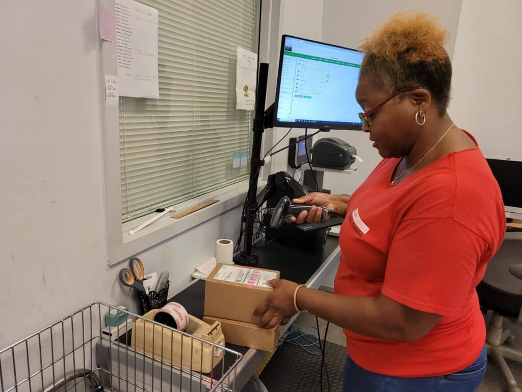 Leggett scans a package next to a computer monitor