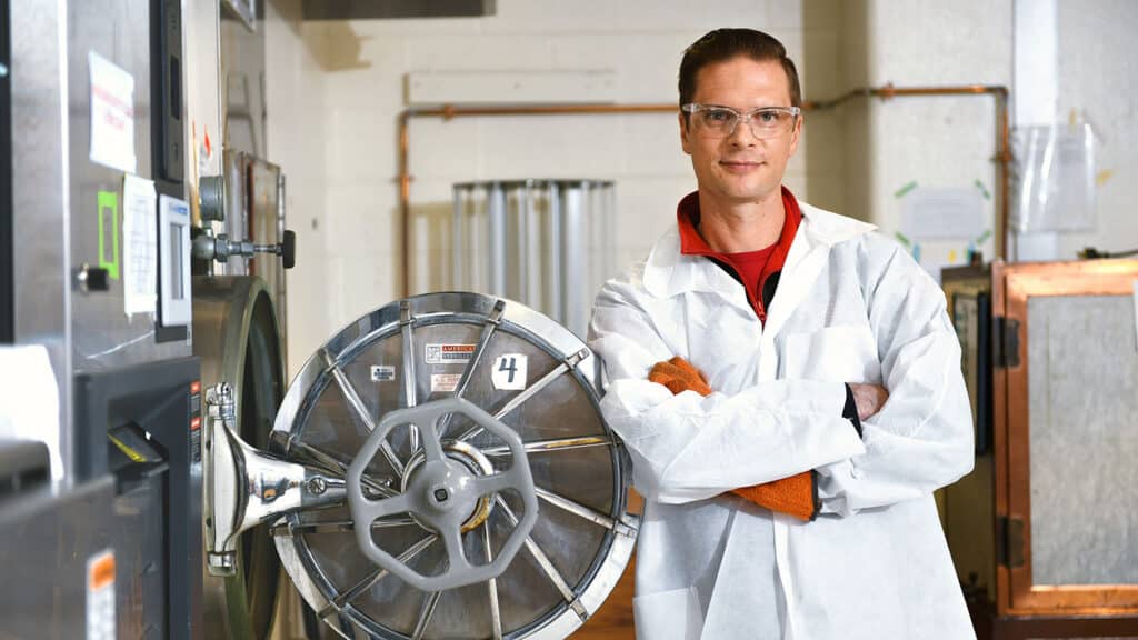 Rodolphe Barrangou, the Todd R. Klaenhammer Distinguished Scholar in Probiotics Research and the lead coordinator for the new biomanufacturing-focused faculty cluster, poses beside equipment in his laboratory.